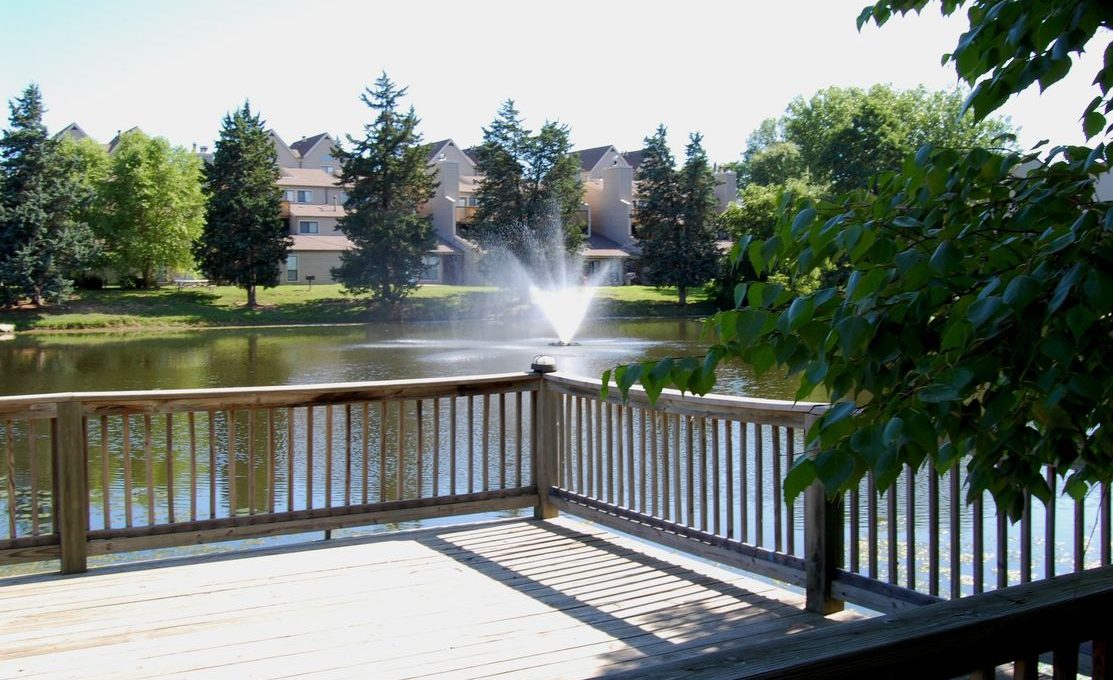 a wooden deck with a fountain and a pond at The Lakeside Village