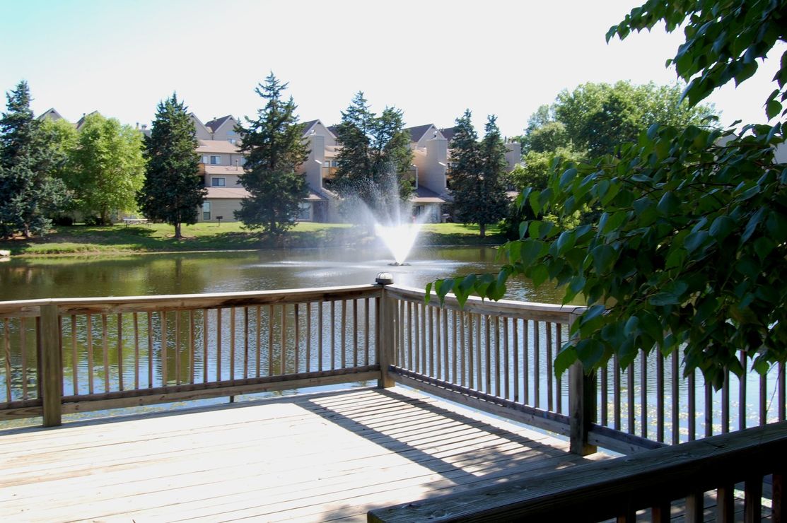 a wooden deck with a fountain and a pond at The Lakeside Village