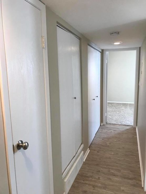 a hallway with white doors and white walls at The Lakeside Village