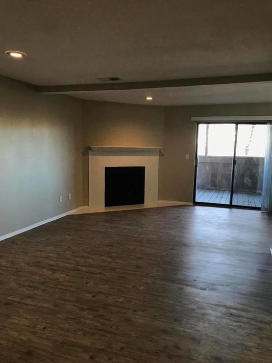 empty living room with hardwood floors and fireplace at The Lakeside Village